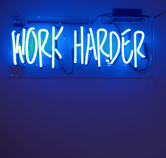 Work hard neon sign reflecting all work and no play motto. Photo credit: Jordan Whitfield