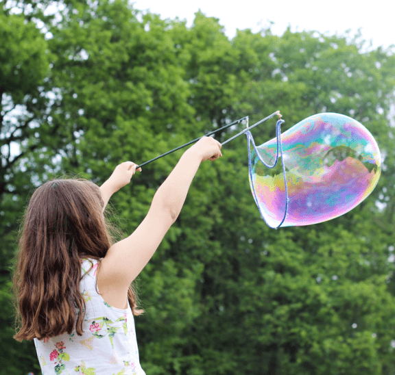 Girl blowing bubbles is playful state of mind. Photo credit Maxime Bhm